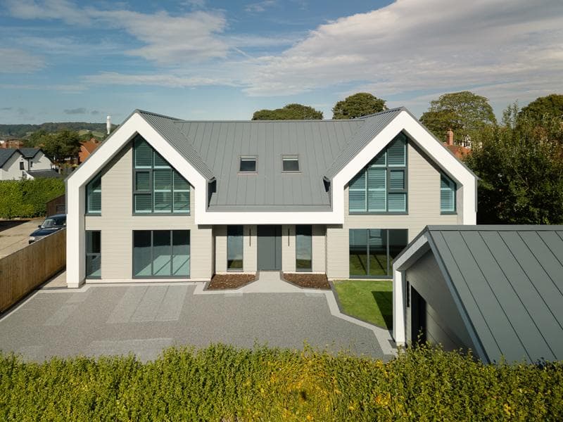 Modern twin-gable home featuring GreenCoat PLX Pural BT standing seam roof